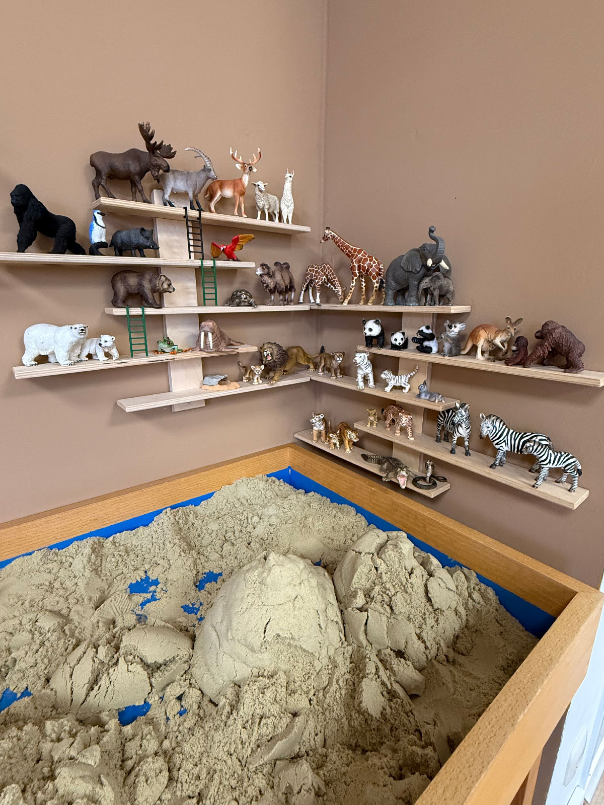 Tischsandkasten mit einigen Tierfiguren zum Spielen