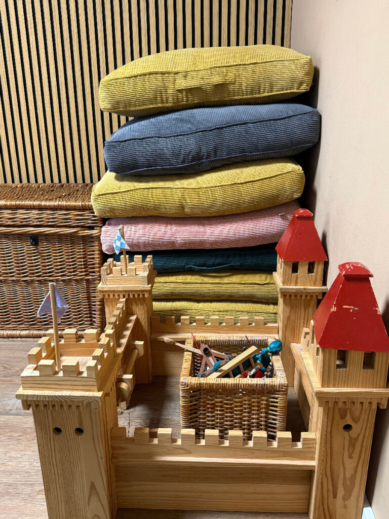 Bild ders Praxisraums mit einer Spielburg und bequemen Sitzkissen